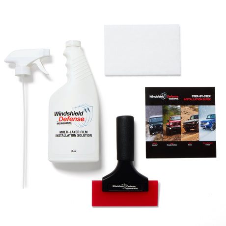 Car windshield cleaning kit with spray bottles, squeegee, and instructional guide on a white background